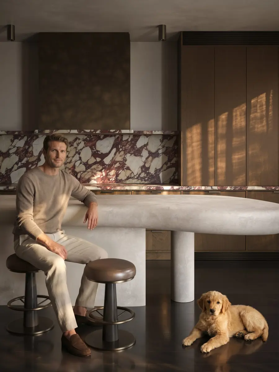 A kitchen render with a man seated at the island and a dog.